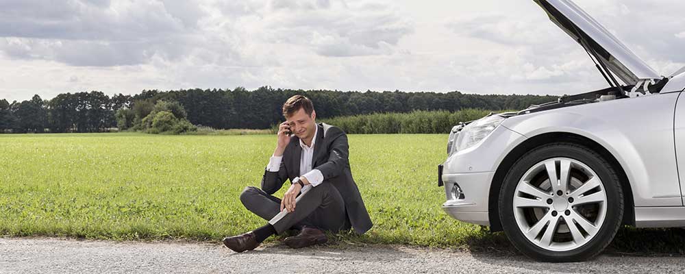 man met pech belt zijn zakelijke autoverzekering